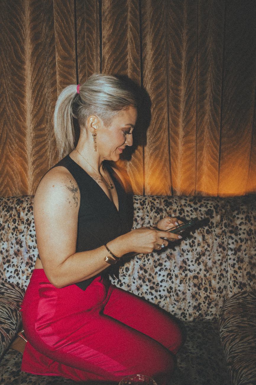 Maria Morgan smiling as she types a message on her phone