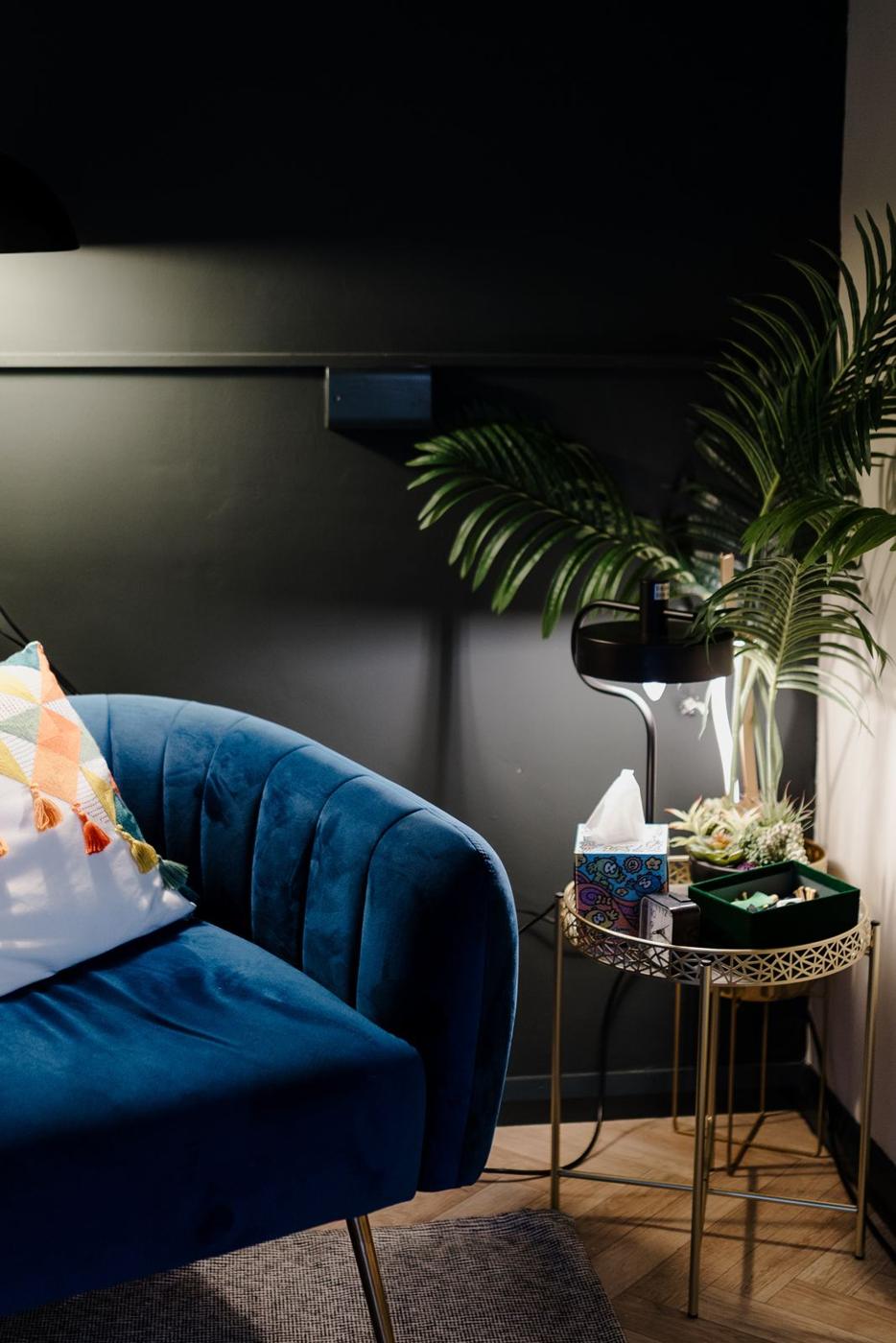 A blue velvet chair, side table and plants in one of our counselling rooms