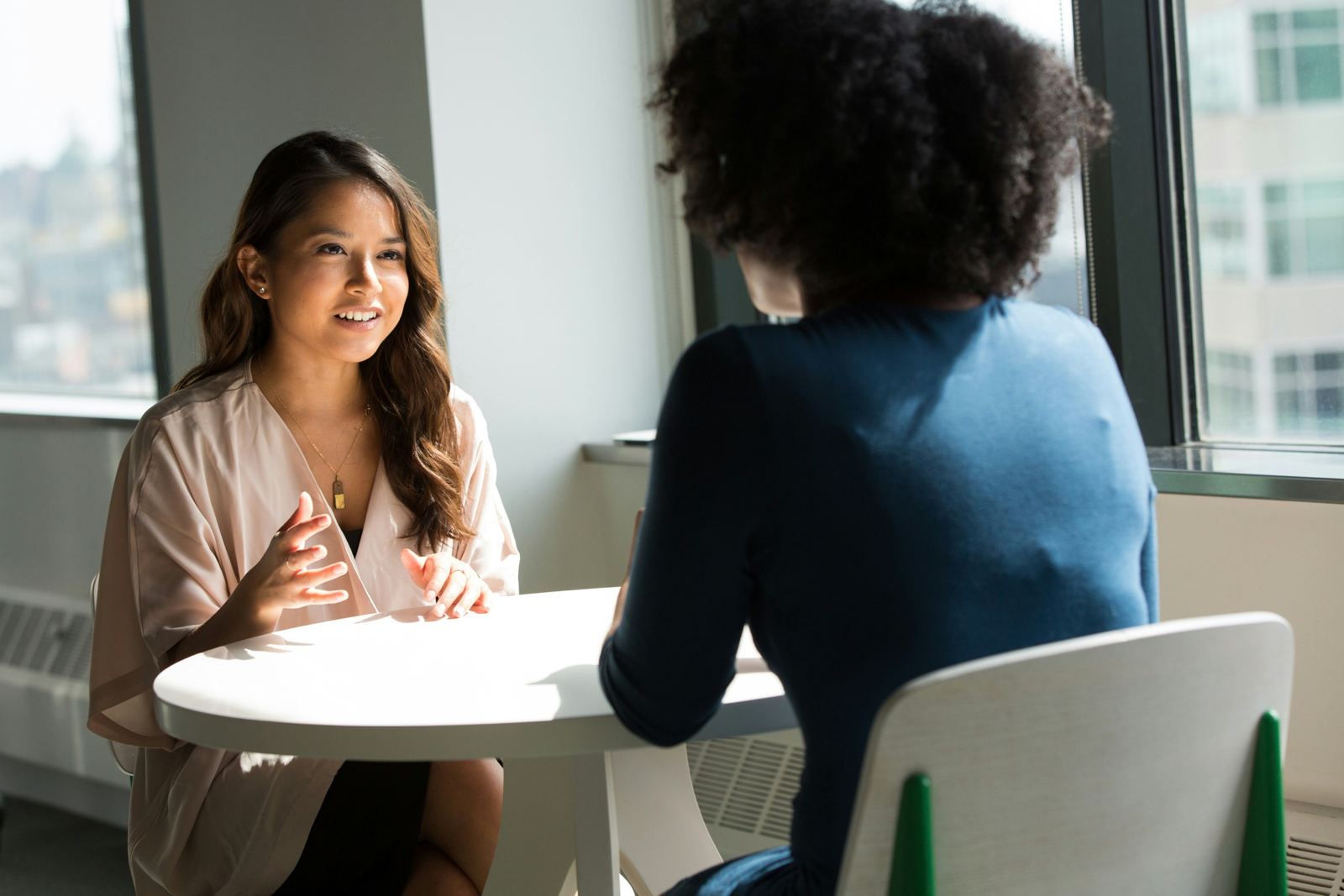 A counsellor listening to a client at a table by the window
